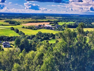 High hilly shores. Oppdal mountain valley landscape background. Sunny day in early summer. View to forest, field and meadows in sunny day with blue sky. Summer hills landscape. Touristic place