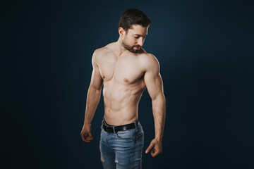 Fototapeta premium Exuding Strength and Confidence: Naked Men's Physique with Six-Pack Abs in Vibrant black Studio Ambiance - A Testament to Masculine Power, Athleticism, and Confidence