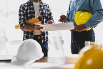 Colleagues architect, contractor and construction engineer are discussing blueprints and planning...