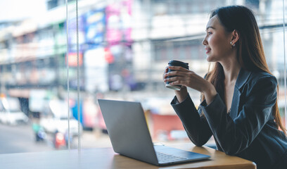 Smiling young asian businesswoman using computer at home office workplace, happy korean employee working on laptop, attractive japanese or chinese woman student studying communicating online with pc