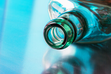 Opened empty glass bottle lying on metal surface