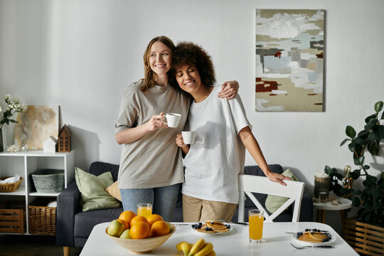Two women in casual attire enjoy a cup of coffee together in their home. - Powered by Adobe