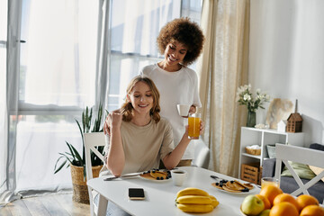 A diverse lesbian couple enjoys breakfast together at home.
