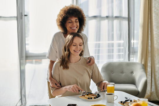 A lesbian couple enjoys breakfast together at home.