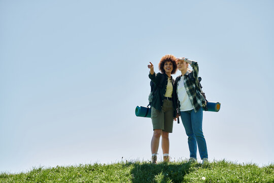 A young lesbian couple hikes through the wilderness, enjoying a sunny day together.