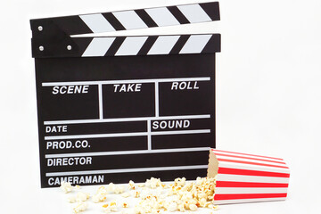 Clapperboard or movie slate black color with popcorn on white background. Cinema industry, video...