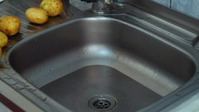 Cleaning filter mesh from debris and food residue after washing dishes, vegetables, peeling of plant ingredients cooking, which stands on sink drain to prevent the sewer pipe from clogging.