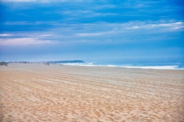 Sea sand sky and summer day. Summer background. The sea and the beach under the blue sky and white clouds. Tropical beach in the evening