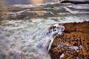 Ocean waves crashing on rocks on a bright day. Portugal