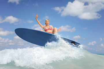 Female surfer jumping with a surfboard