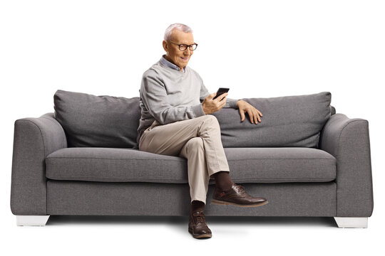 Elderly man sitting on a sofa and looking at a smartphone