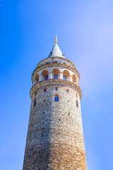 Fototapeta premium The Galata Tower in Istanbul, Turkey, stands tall and prominent against a clear blue sky. 
