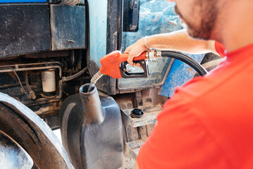 Close-up of Young Farmer Refueling a Tractor With a Gas Pump in the Countryside During Daytime © GALDRIC