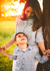 Obraz premium Beautiful mother with son on sunset field