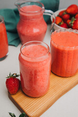 Fruit smoothie in transparent cups. Red strawberry smoothie on a concrete background. The concept of healthy eating. Top view