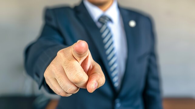 Motivated businessman points directly at viewer, leadership and encouragement concept