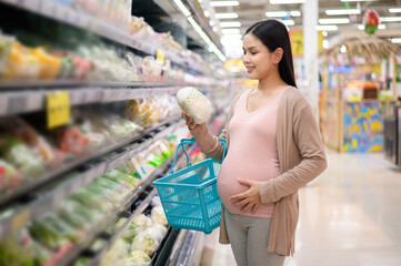 Beautiful pregnant woman shopping healthy food at grocery shop