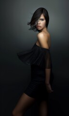 Fototapeta premium A brunette woman with a bob hairstyle wears a black dress on a black background. Fashion and beauty.