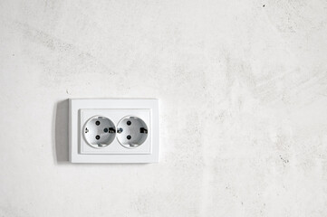 A white electrical outlet mounted on a white wall