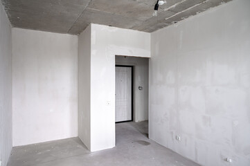 The room is vacant, adorned with white walls and a solitary door inside