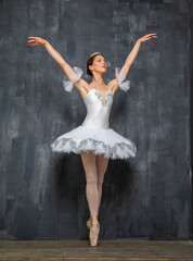 Full length portrait of an adult female ballerina in a white tutu