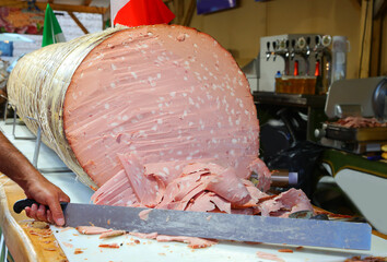 Italian salami called  mortadella GIGANTE sliced with a knife during the town festival © ChiccoDodiFC