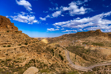 Widok na skaliste góry Dahar, tapeta. Niebieski kolor nieba i palące słońce, skała, kamień, górski krajobraz, egzotyczny kraj, Tunezja © anettastar