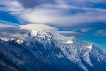 Tour du Montblanc beautiful mountain ladscapes of the Alps green valley, snow summit of Montblanc and rocky peaks of Aiguille du Midi in summer sunny weather blue sky, trekking and hiking in Chamonix