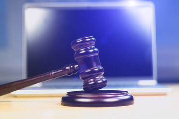 Judge Hammer for adjudication with wooden stand and laptop on it.