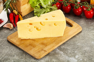 Swiss Maasdam cheese triangle over board