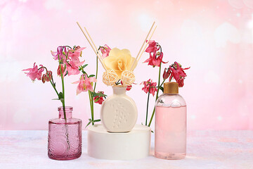 Spa and wellness composition, aromatic rose water, lilac incense sticks and aquilegia flowers....