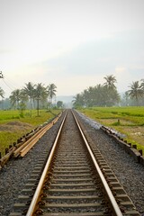 Railway tracks in rice fields. Beautiful views of rural Indonesia