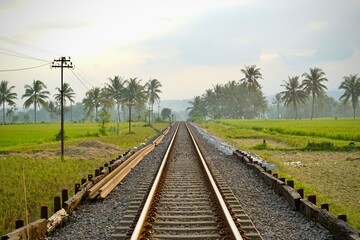 Railway tracks in rice fields. Beautiful views of rural Indonesia