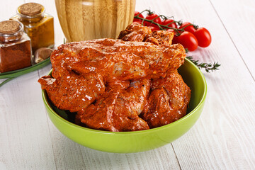 Raw turkey shoulder wing in Indian tandoori marinade