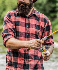 Fisherman throws the fishing rod into the water. Fisherman on the river bank. Fisherman in his hand...