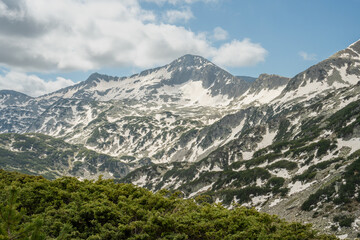 Fototapeta premium Banderishki Chukar peak in Pirin Mountains is still covered by patches of snow in early June