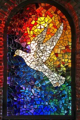 Fototapeta premium Colorful and beautiful stained glass window of a white pigeon in a gorgeous majestic frame