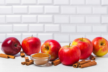 Apples with cinnamon on a textured wooden background. Fragrant red spiced apples with cinnamon sticks and star anise. Apple slices with spicy spices. Place for text. Copy space. Harvesting. Fruits.
