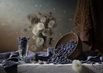 Country still life with dandelions and scattered honeysuckle on a dark background © 02irina