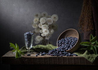 Country still life with dandelions and scattered honeysuckle on a dark background