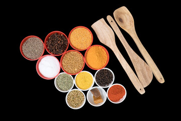 three wooden spatulas with Cumin Seeds, Clove, Yellow Split Mustard Seeds, salt, Fenugreek Seeds, turmeric powder, Fennel Seeds, Mustard Seeds, Black Pepper, Coriander Seeds, Asafoetida, and chili pep