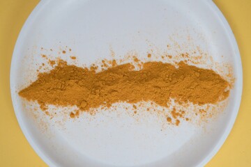 A scattering of red turmeric powder on a white background.