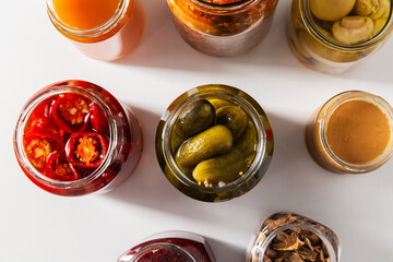 food, eating and preserve concept - close up of jars with preserves on white background, top view