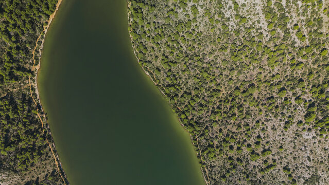 Drone view directly from above on lake surrounded by coniferous forests in Telascica National Park, Croatia