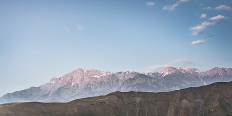 Panoramic mountain landscape in the mountains in the evening at sunset for background in the mountains of Tajikistan, the texture of hills and high mountains minimalist in the evening