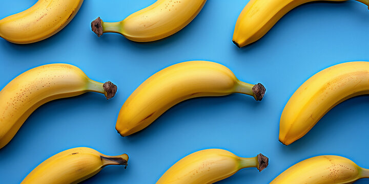 Fresh yellow bananas laying flat in an overhead view in a  repeated pattern