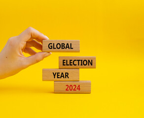 Global Election year 2024 symbol. Concept words Global Election year 2024 on wooden blocks. Beautiful yellow background. Businessman hand. Business and Global Election year 2024 concept. Copy space