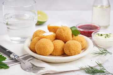 Plate with delicious fried mozzarella balls on light background, closeup