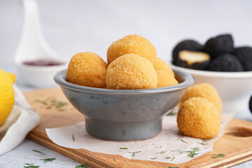 Bowl with delicious fried mozzarella balls on table, closeup