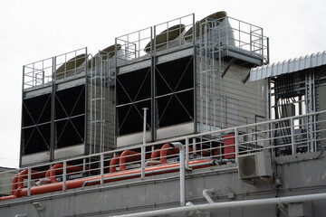 Three large cooling towers are on top of a building